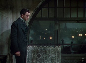 Movie still from “The Four Feathers” (1939), directed by Zoltan Korda – A man standing in front of a window at night; Medium shot, Low angle