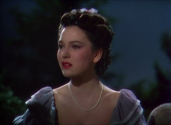 Movie still from “The Four Feathers” (1939), directed by Zoltan Korda – A woman with a pearl necklace is looking to her left; Close Up shot, Over the shoulder angle