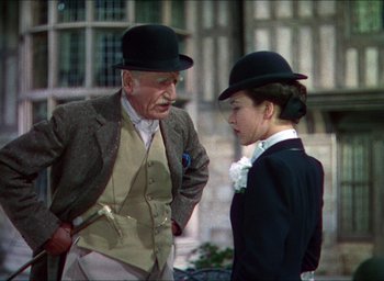 Movie still from “The Four Feathers” (1939), directed by Zoltan Korda – An older man and a young woman wearing hats; Medium shot, Over the shoulder angle