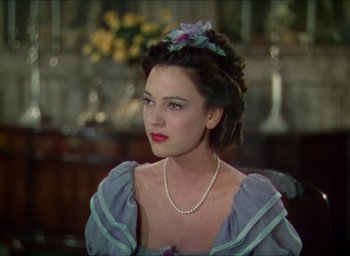 Movie still from “The Four Feathers” (1939), directed by Zoltan Korda – A woman in a blue dress with a flower in her hair; Close Up shot, Over the shoulder angle