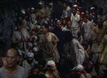 Movie still from “The Four Feathers” (1939), directed by Zoltan Korda – A large group of people gathered together in a room; Wide shot, High angle