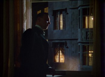 Movie still from “The Four Feathers” (1939), directed by Zoltan Korda – A man standing in front of a window at night; Medium shot, Low angle