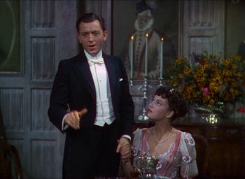 Movie still from “The Four Feathers” (1939), directed by Zoltan Korda – A man and a woman dressed in formal wear; Medium shot, High angle