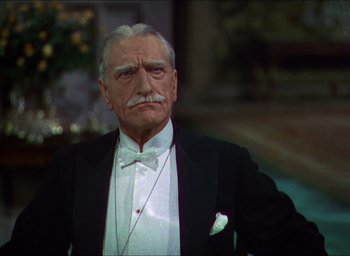 Movie still from “The Four Feathers” (1939), directed by Zoltan Korda – An older man in a tuxedo with a mustache; Close Up shot, Over the shoulder angle