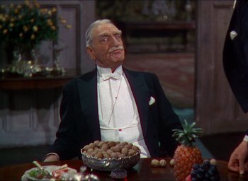Movie still from “The Four Feathers” (1939), directed by Zoltan Korda – An older man sitting at a table with a bowl of nuts; Medium shot, High angle