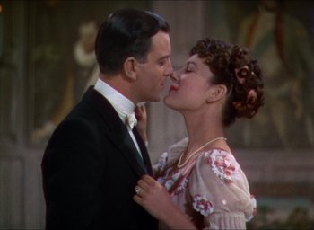 Movie still from “The Four Feathers” (1939), directed by Zoltan Korda – A man and a woman kissing each other in front of a wall; Close Up shot, High angle