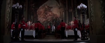 Movie still from “The Four Feathers” (2002), directed by Shekhar Kapur – A group of people standing in front of a wall with a painting on it; Extreme Wide shot, Low angle