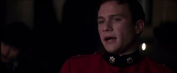 Movie still from “The Four Feathers” (2002), directed by Shekhar Kapur – A man in a red jacket is looking at the camera; Close Up shot, Over the shoulder angle