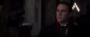 Movie still from “The Four Feathers” (2002), directed by Shekhar Kapur – A man in a black coat and a red scarf; Close Up shot, Over the shoulder angle