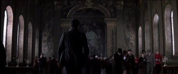Movie still from “The Four Feathers” (2002), directed by Shekhar Kapur – A man in a coat and hat walking in a room; Wide shot, Low angle