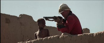 Movie still from “The Four Feathers” (2002), directed by Shekhar Kapur – A man and a child are playing with a toy gun; Medium shot, Over the shoulder angle