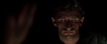 Movie still from “The Four Feathers” (2002), directed by Shekhar Kapur – A person with his eyes closed in the dark; Close Up shot, Low angle
