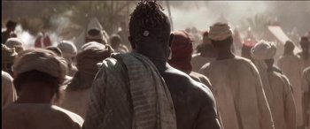 Movie still from “The Four Feathers” (2002), directed by Shekhar Kapur – A man in a crowd of people wearing a head scarf; Close Up shot, Over the shoulder angle