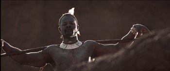 Movie still from “The Four Feathers” (2002), directed by Shekhar Kapur – A man with a feather in his hair and a necklace on; Close Up shot, Low angle