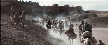 Movie still from “The Four Feathers” (2002), directed by Shekhar Kapur – A group of people riding horses down a dirt road; Extreme Wide shot, High angle