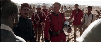 Movie still from “The Four Feathers” (2002), directed by Shekhar Kapur – A group of men in red uniforms walking on a beach; Medium shot, Over the shoulder angle