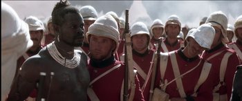 Movie still from “The Four Feathers” (2002), directed by Shekhar Kapur – A group of men in red and white uniforms holding guns; Close Up shot, Over the shoulder angle