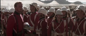 Movie still from “The Four Feathers” (2002), directed by Shekhar Kapur – A group of people in red and white uniforms; Medium shot, Over the shoulder angle