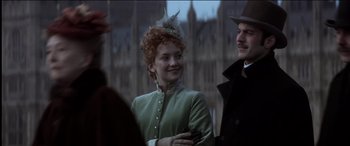 Movie still from “The Four Feathers” (2002), directed by Shekhar Kapur – A woman in a green coat and a man in a black suit; Medium shot, Low angle
