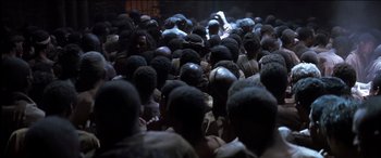 Movie still from “The Four Feathers” (2002), directed by Shekhar Kapur – A group of people gathered together in a dark room; Medium shot, High angle