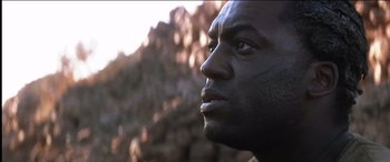 Movie still from “The Four Feathers” (2002), directed by Shekhar Kapur – A man's face in front of a rock wall; Close Up shot, Low angle