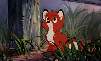 Movie still from “The Fox and the Hound” (1981), directed by Richard Rich – A cartoon of a red fox sitting in the grass; Medium shot, High angle