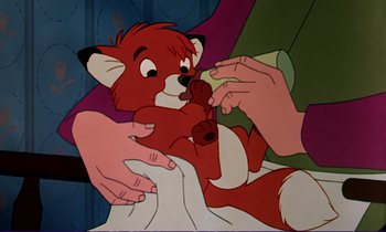 Movie still from “The Fox and the Hound” (1981), directed by Richard Rich – An animated fox being held up by a person; Close Up shot, Overhead angle