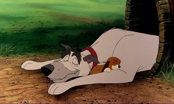 Movie still from “The Fox and the Hound” (1981), directed by Richard Rich – A dog laying on the ground next to a puppy; Wide shot, High angle