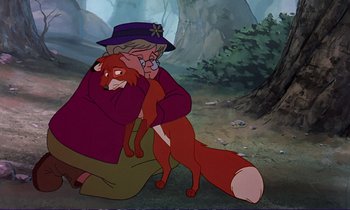 Movie still from “The Fox and the Hound” (1981), directed by Richard Rich – An old woman holding a red fox in her arms; Medium shot, Over the shoulder angle