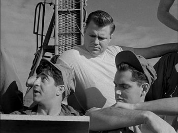 Movie still from “The Frogmen” (1951), directed by Lloyd Bacon – A group of men standing next to each other on a boat; Medium shot, Low angle