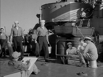 Movie still from “The Frogmen” (1951), directed by Lloyd Bacon – A group of people sitting on the deck of a boat; Wide shot, High angle