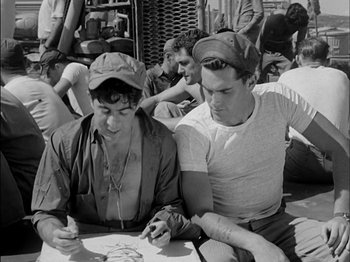 Movie still from “The Frogmen” (1951), directed by Lloyd Bacon – A couple of men sitting next to each other on top of a table; Medium shot, High angle