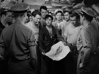 Movie still from “The Frogmen” (1951), directed by Lloyd Bacon – A group of men standing next to each other in a room; Medium shot, High angle