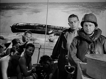 Movie still from “The Frogmen” (1951), directed by Lloyd Bacon – A black and white photo of a group of men on a boat; Medium shot, High angle