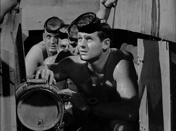 Movie still from “The Frogmen” (1951), directed by Lloyd Bacon – A group of men wearing goggles and diving gear; Medium shot, High angle