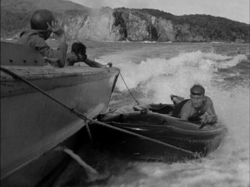 Movie still from “The Frogmen” (1951), directed by Lloyd Bacon – A man in a boat in the water with two other men; Wide shot, High angle
