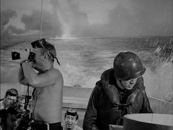 Movie still from “The Frogmen” (1951), directed by Lloyd Bacon – Two men on a boat in the water; Medium shot, Over the shoulder angle