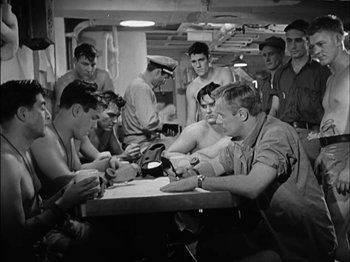 Movie still from “The Frogmen” (1951), directed by Lloyd Bacon – A black and white photo of a group of men sitting at a table; Medium shot, High angle