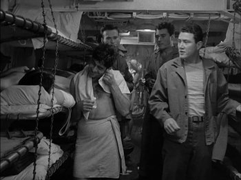 Movie still from “The Frogmen” (1951), directed by Lloyd Bacon – A black and white photo of a group of people in a room; Medium shot, Low angle