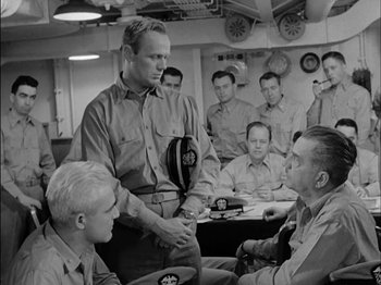 Movie still from “The Frogmen” (1951), directed by Lloyd Bacon – A group of men sitting in a room; Medium shot, Over the shoulder angle