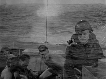 Movie still from “The Frogmen” (1951), directed by Lloyd Bacon – A black and white photo of a group of people on a boat; Medium shot, Over the shoulder angle