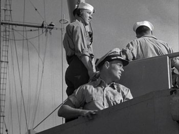 Movie still from “The Frogmen” (1951), directed by Lloyd Bacon – A group of men standing next to each other on top of a boat; Medium shot, Low angle