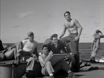 Movie still from “The Frogmen” (1951), directed by Lloyd Bacon – A group of men sitting next to each other on a boat in the ocean; Wide shot, Low angle