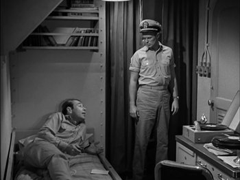 Movie still from “The Frogmen” (1951), directed by Lloyd Bacon – An old photo of two men in a room; Medium shot, High angle