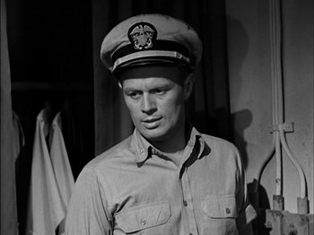 Movie still from “The Frogmen” (1951), directed by Lloyd Bacon – Black and white photograph of a man wearing a hat; Close Up shot, Low angle