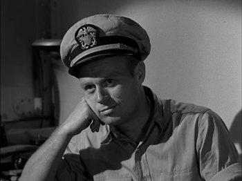 Movie still from “The Frogmen” (1951), directed by Lloyd Bacon – Black and white photograph of a man wearing a hat; Close Up shot, High angle