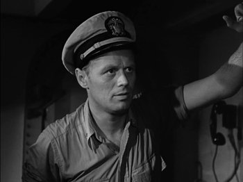 Movie still from “The Frogmen” (1951), directed by Lloyd Bacon – A man wearing a hat with a pipe in his mouth; Close Up shot, Low angle