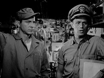 Movie still from “The Frogmen” (1951), directed by Lloyd Bacon – A black and white photo of two men in uniform; Medium shot, Low angle
