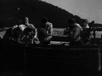 Movie still from “The Frogmen” (1951), directed by Lloyd Bacon – A black and white photo of a group of men on a boat; Wide shot, High angle