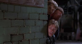 Movie still from “The Full Monty” (1997), directed by Peter Cattaneo – A group of young men standing next to a brick wall; Medium shot, Low angle